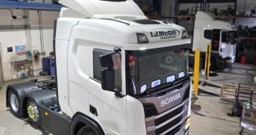  Heavy-duty Scania truck inside a warehouse workshop for maintenance or repair.